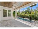 Covered patio overlooking a luxurious pool and lush landscaping creating a private backyard oasis at 4614 W Lowell Ave, Tampa, FL 33629