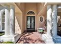 Inviting entryway features a decorative glass door, brick flooring, and elegant white columns at 5611 Eagleglen Pl, Lithia, FL 33547