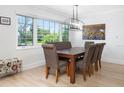 Light filled dining area with modern chandelier, large picture window and decorative sunflower painting at 715 44Th Ne Ave, St Petersburg, FL 33703