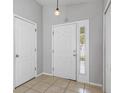 Inviting entryway features tiled flooring, a front door with sidelight, and a neutral color palette at 7233 Lumber Port Dr, Ruskin, FL 33573