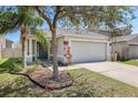Well-kept home with a two-car garage, front yard landscaping, and mature trees at 7233 Lumber Port Dr, Ruskin, FL 33573