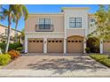 Inviting townhome featuring a paver driveway and three garage doors at 7244 Hamilton Rd # 7244, Bradenton, FL 34209