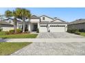 Inviting two-story home with a three-car garage and well-manicured landscaping at 8766 Shadyside Ln, Land O Lakes, FL 34637