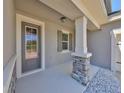 Charming front porch featuring stone accents, a tiled floor and neutral colored siding at 10708 Planer Picket Dr, Riverview, FL 33569