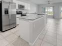 Modern kitchen featuring an island, white cabinets, granite countertops, and stainless steel appliances at 12309 Grizzly Ln, New Port Richey, FL 34654