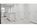 Bright kitchen featuring white cabinets, an island, and stainless steel appliances at 12309 Grizzly Ln, New Port Richey, FL 34654