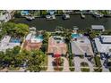 An aerial view of a waterfront home featuring a private pool, lush landscaping, and ample outdoor space for relaxation at 1233 Eden Isle Ne Dr, St Petersburg, FL 33704