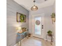 Bright entryway with light gray walls, stylish console table, and neutral tile floors at 12960 Conquistador Loop, Spring Hill, FL 34610