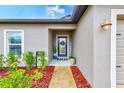 Inviting home exterior showcasing the front door, landscaping, and a window with natural lighting at 12960 Conquistador Loop, Spring Hill, FL 34610
