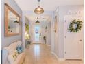 Welcoming hallway with a decorative bench, stylish lighting, and an open view to the front door at 12960 Conquistador Loop, Spring Hill, FL 34610