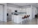 Modern kitchen featuring stainless steel appliances, white cabinetry, a stylish backsplash, and a breakfast bar at 13298 High Springs Ave, Port Charlotte, FL 33981