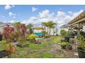 Scenic backyard with vibrant plants, cozy swing, mature palm trees, and well-maintained lawn, ideal for relaxation at 14407 Alistar Manor Dr, Wimauma, FL 33598