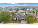 A high aerial shows the neighborhood and a home with a three-car garage, stone accents, and landscaping at 18413 Eastwyck Dr, Tampa, FL 33647