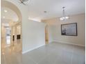 An open-concept living area showcasing tile flooring, decorative arches, and a modern chandelier at 18413 Eastwyck Dr, Tampa, FL 33647