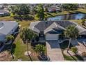 Aerial view of a well-maintained home featuring a brick driveway and mature palm trees in a quiet neighborhood at 1933 Grand Cypress Ln, Sun City Center, FL 33573