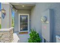 Inviting front entrance featuring stone accents, a covered porch, and a black front door at 21385 Darter Rd, Land O Lakes, FL 34638