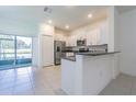 Bright kitchen with white cabinets, granite countertops, stainless steel appliances, and tile flooring at 21385 Darter Rd, Land O Lakes, FL 34638