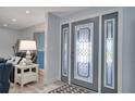 Inviting foyer with tile floors, a decorative front door, and a glimpse into the living area at 218 Leeward Is, Clearwater Beach, FL 33767