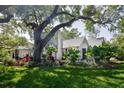 Beautiful backyard featuring a well-maintained lawn, lovely plants, and a charming patio with outdoor seating at 2521 Driftwood Se Rd, St Petersburg, FL 33705