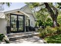 Close up of outdoor patio with pavers, double doors, potted plants, and comfortable seating arrangement at 2521 Driftwood Se Rd, St Petersburg, FL 33705