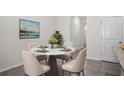 Bright dining area features a round table, four chairs, and a large colorful painting on the wall at 2892 Beluga Bay Dr, Odessa, FL 33556