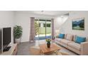 Bright living room featuring neutral walls, tile floors, comfortable seating and sliding glass doors to outdoor space at 2892 Beluga Bay Dr, Odessa, FL 33556