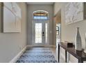 Inviting foyer with tile floors, arched transom window above the door, and decorative lighting at 329 Laurel Falls Dr, Apollo Beach, FL 33572