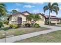 Beautiful tan home with stone accents, a two-car garage, a tile roof and professional landscaping at 329 Laurel Falls Dr, Apollo Beach, FL 33572