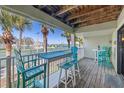 Spacious covered balcony with seating overlooking the tennis courts and harbor at 442 Sandy Hook Rd, Treasure Island, FL 33706