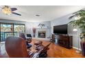 Inviting living room with a cozy fireplace, hardwood floors, and sliding doors to the balcony at 442 Sandy Hook Rd, Treasure Island, FL 33706