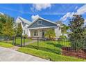 Charming home exterior with manicured lawn, a sleek black fence, and mature trees enhancing curb appeal at 445 29Th N Ave, St Petersburg, FL 33704
