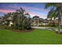 Imposing home with manicured lawn, lush landscaping, and a welcoming circular driveway at 5384 Mira Vista Dr, Palm Harbor, FL 34685