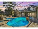 Enclosed pool area features a jacuzzi, waterfall feature, tiled flooring and an outdoor kitchen at 5384 Mira Vista Dr, Palm Harbor, FL 34685