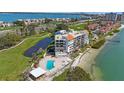 Aerial view of waterfront condo building with pool, pond, beach, and golf course nearby at 5700 Escondida S Blvd # 506, St Petersburg, FL 33715
