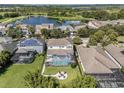 Stunning aerial view of a home with a private pool, patio area, and well-kept lawn, ideal for outdoor living at 6617 Park Strand Dr, Apollo Beach, FL 33572