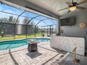 Inviting screened-in pool area with a swim-up bar, fire pit, and ample seating for entertaining at 6617 Park Strand Dr, Apollo Beach, FL 33572