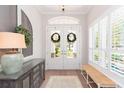 Bright foyer with natural light, double doors with wreaths, and stylish decor, creating a warm welcome at 6644 Par Ct, Wesley Chapel, FL 33544