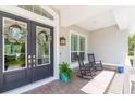 Inviting front porch with rocking chairs and double doors adorned with wreaths, perfect for relaxing at 6644 Par Ct, Wesley Chapel, FL 33544