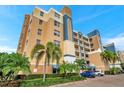Low angle view of a modern condo building with colorful accents, landscaping, and a parking area at 960 Starkey Rd # 5303, Largo, FL 33771