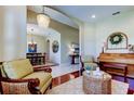 Comfortable living room with an elegant chandelier, piano, and comfortable seating at 14813 Princewood Ln, Land O Lakes, FL 34638