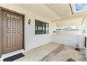 Welcoming front porch featuring a brown door, small window, and a white brick accent wall at 1515 Danbury Dr, Sun City Center, FL 33573