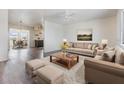 Bright living room featuring modern furniture and hardwood floors with open view to dining and kitchen at 1515 Danbury Dr, Sun City Center, FL 33573