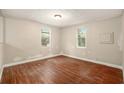 Empty bedroom showcasing wood-look flooring and natural light from two windows at 15165 Waverly St, Clearwater, FL 33760