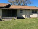 Spacious backyard featuring a screened patio and green lawn at 1567 Patton Dr, Dunedin, FL 34698