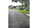 Wide paved driveway leading up to a home in a quiet neighborhood surrounded by mature trees at 1567 Patton Dr, Dunedin, FL 34698