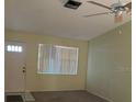 Inviting living room with a ceiling fan, neutral paint, and natural light streaming through the large window at 1567 Patton Dr, Dunedin, FL 34698