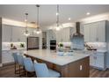 Bright kitchen with stainless steel appliances, a spacious island with pendant lighting, and modern cabinetry at 18604 Arbor Vista Dr, Venice, FL 34293