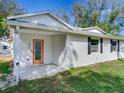 Inviting front porch with an orange-framed glass door and dark shuttered windows at 2827 W Bay Haven Dr, Tampa, FL 33611