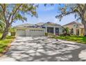 Charming one-story home with a three-car garage, screened porch, and well-manicured lawn and garden at 3629 Mossy Oak Cir, Land O Lakes, FL 34639