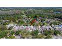 Aerial view of the home nestled in a lush, green, wooded community at 370 S Woodlands Dr, Oldsmar, FL 34677